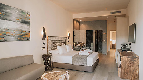 Luxuriöses Hotelzimmer mit Sofa, Bett, Schreibtisch und offenem Bad. Qhotels: Zahara Beach & SPA