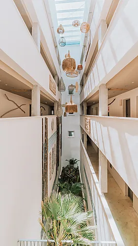 Indoor atrium with rattan lamps and lush plants, a beautiful hotel Qhotels: Zahara Beach & SPA view.