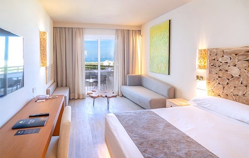 a hotel room with a bed , couch , desk and television .