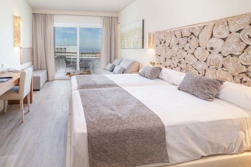 a hotel room with two beds and a wooden headboard
