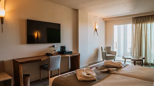 Luxuriöses Hotelzimmer mit zwei Betten, Schreibtisch, TV und Balkontür. Qhotels: Zahara Beach & SPA