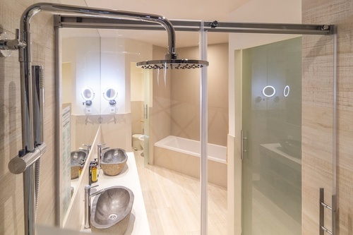 a bathroom with two sinks and a shower head