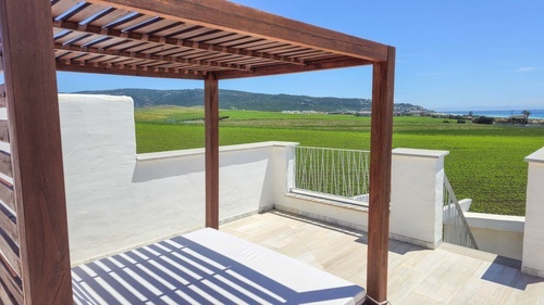 a balcony with a view of a field and the ocean