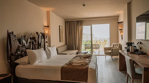 Geräumiges Hotelzimmer mit Bett, Sofa, Schreibtisch und Balkonblick Qhotels: Zahara Beach & SPA