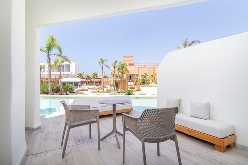 a balcony with a table and chairs overlooking a swimming pool