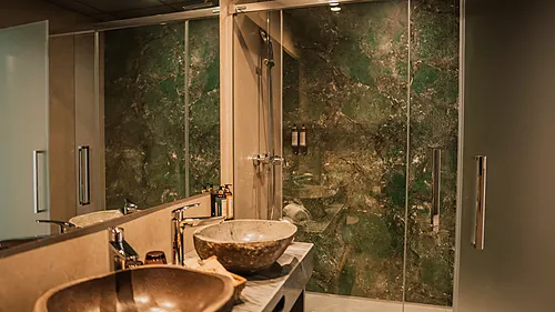 Luxuriöses Badezimmer mit grüner Marmordusche und Doppelwaschbecken – Ihr Qhotels: Zahara Beach & SPA erwartet Sie.
