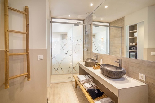 a bathroom with two sinks and a walk in shower