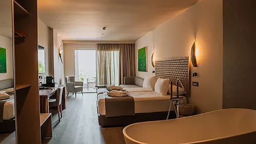 Modern Hotelzimmer mit Doppelbett, Badewanne und Balkonblick. Qhotels: Zahara Beach & SPA