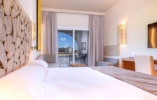a hotel room with a bed , couch , desk and television .