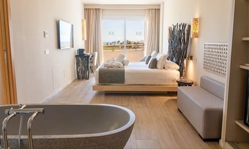 Auf einem Balkon mit Blick auf den Ozean steht ein Himmelbett .