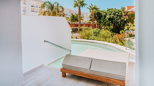 Luxury hotel room balcony with private plunge pool, lounge chair, and tropical plants. Qhotels: Zahara Beach & SPA