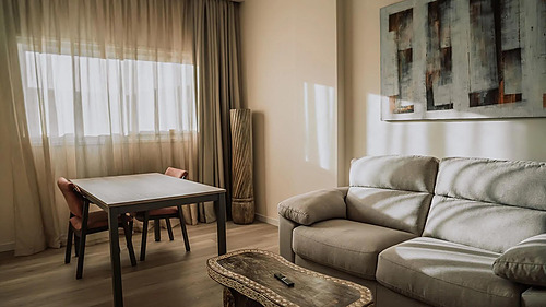 Gemütliches Wohnzimmer mit Sofa und Esstisch. Qhotels: Zahara Beach & SPA