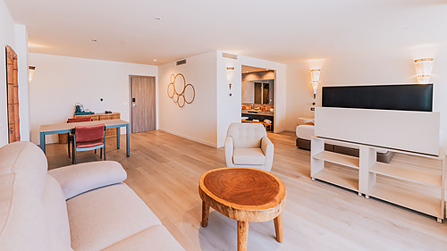 Spacious hotel suite with a living area, dining table, and open bathroom access. Qhotels: Zahara Beach & SPA