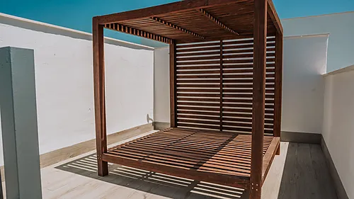 Holzbett mit Lamellendach auf einer Dachterrasse, ideal für Qhotels: Zahara Beach & SPA