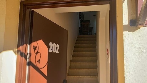 una puerta marrón con el número 202 encima