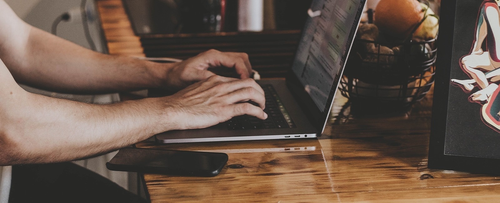 un hombre está usando una computadora portátil en una mesa de madera