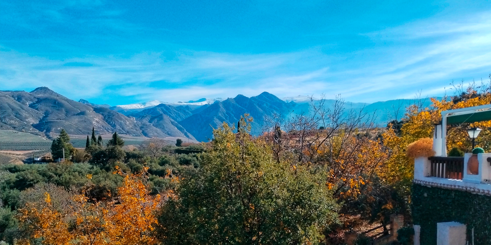 a balcony overlooking a valley with mountains in the background