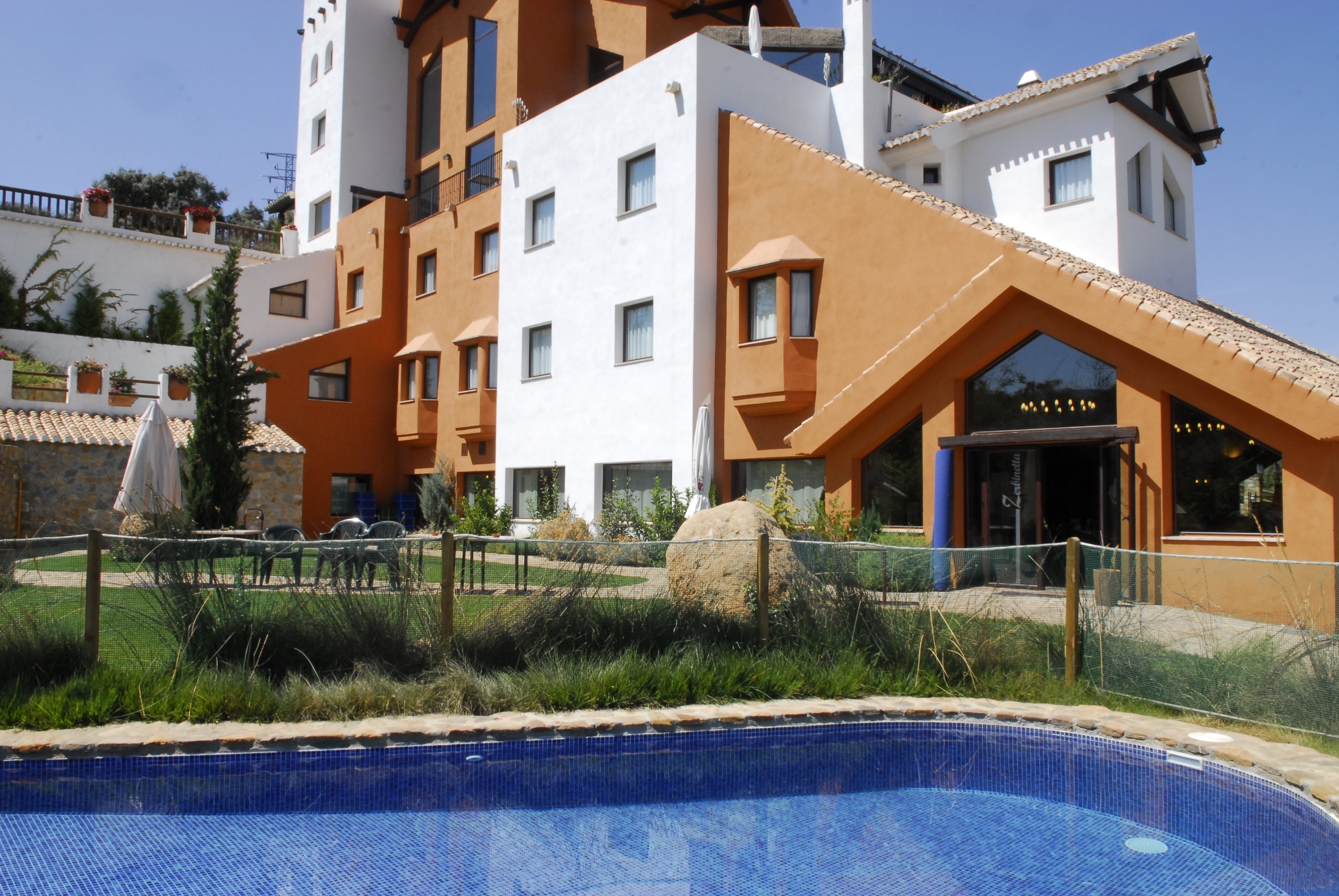 un gran edificio naranja y blanco con una piscina al frente