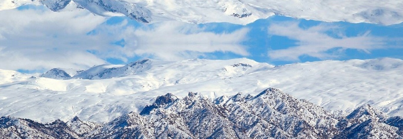 montañas cubiertas de nieve con un cielo azul en el fondo