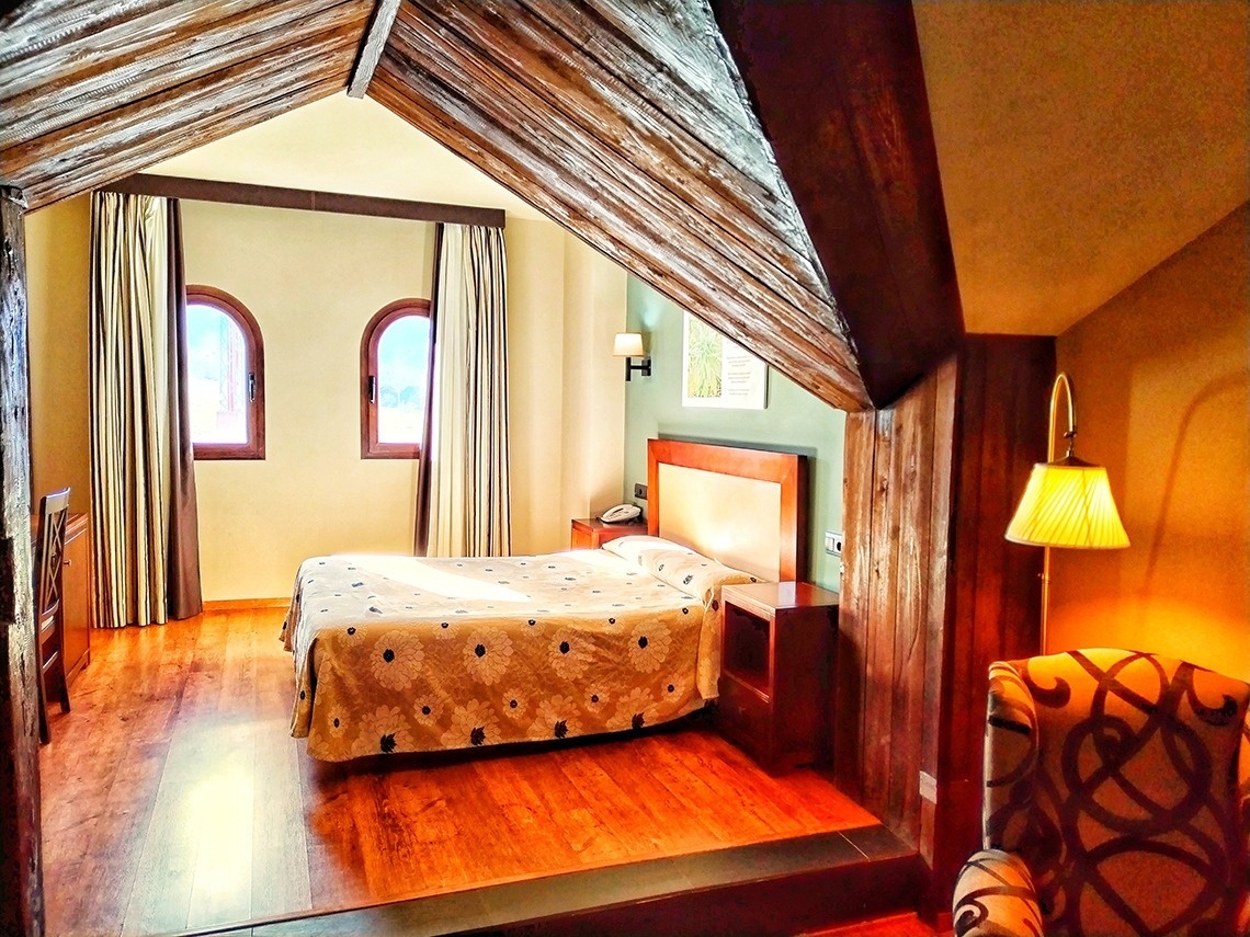 una habitación de hotel con una cama y una lámpara