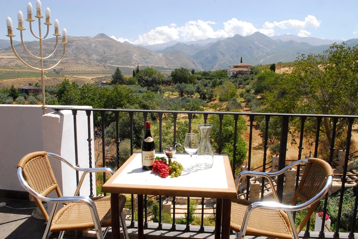 two chairs and a table with a bottle of wine on it