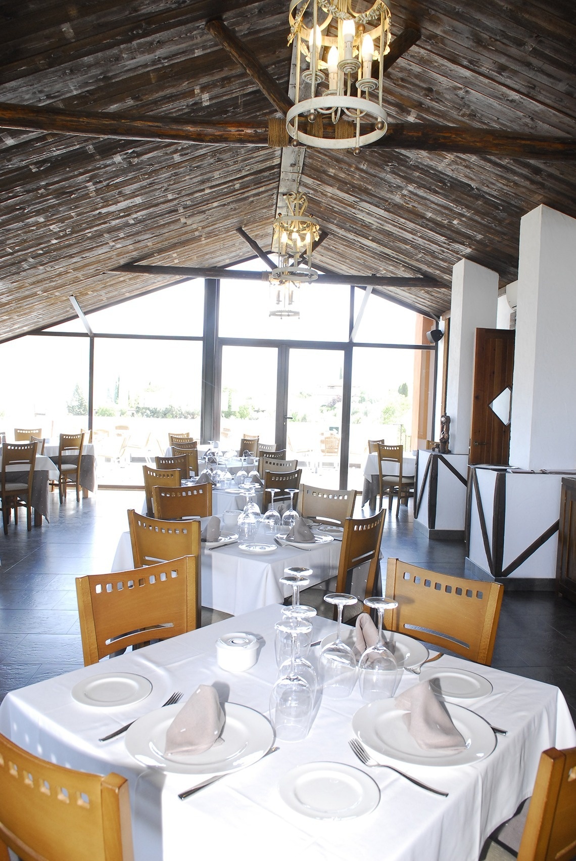 a restaurant filled with tables and chairs with plates and glasses on them