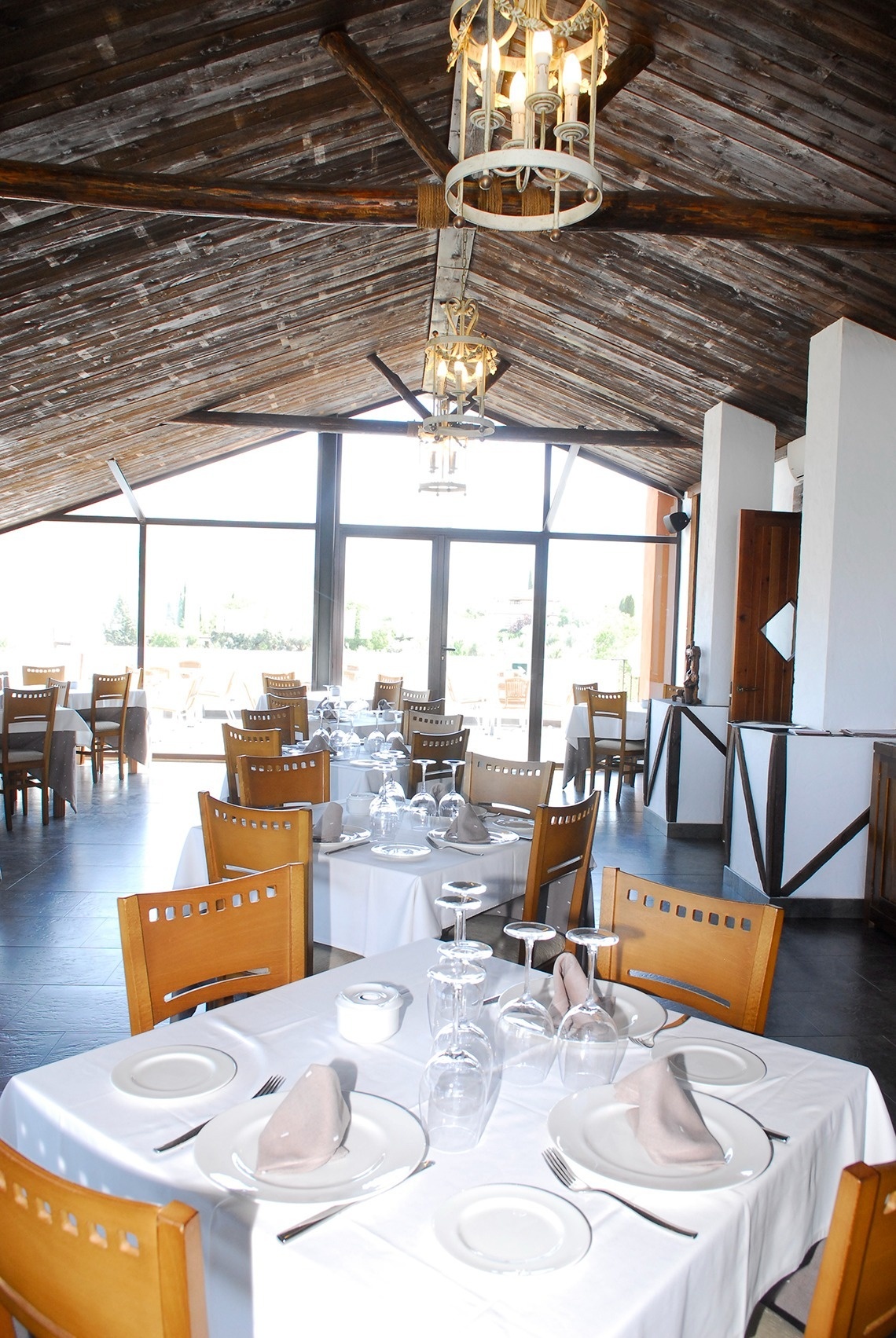 a restaurant filled with tables and chairs with plates and glasses on them