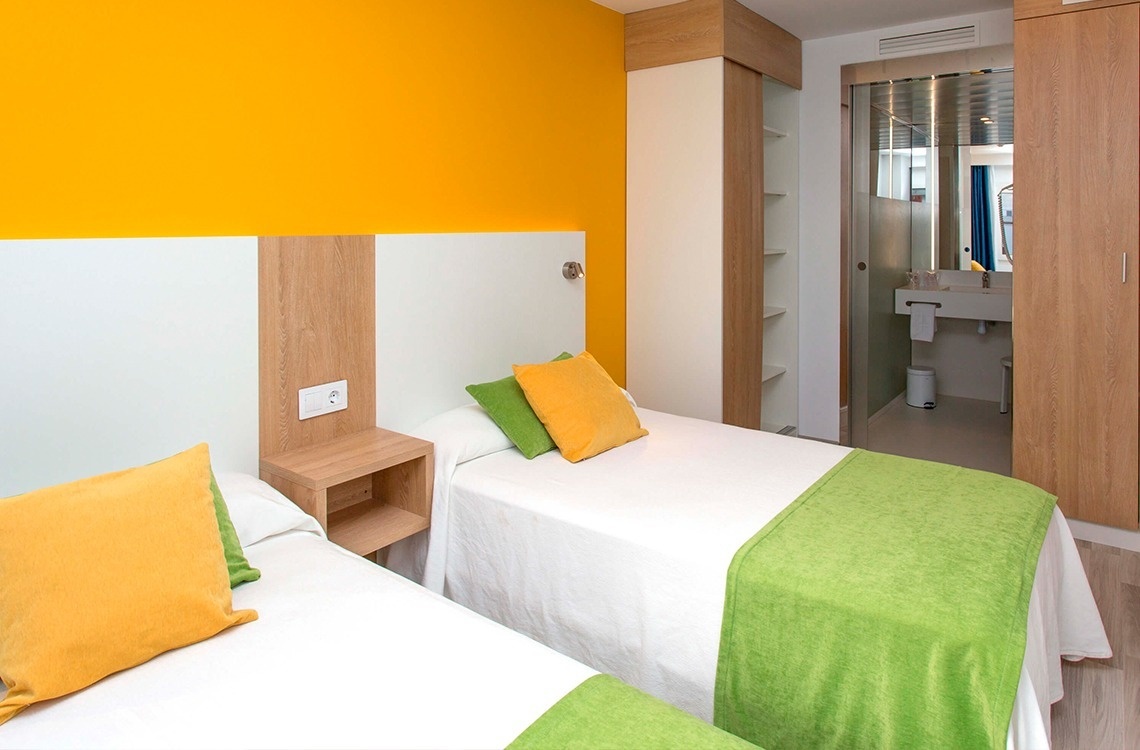 una habitación de hotel con dos camas y una mesa