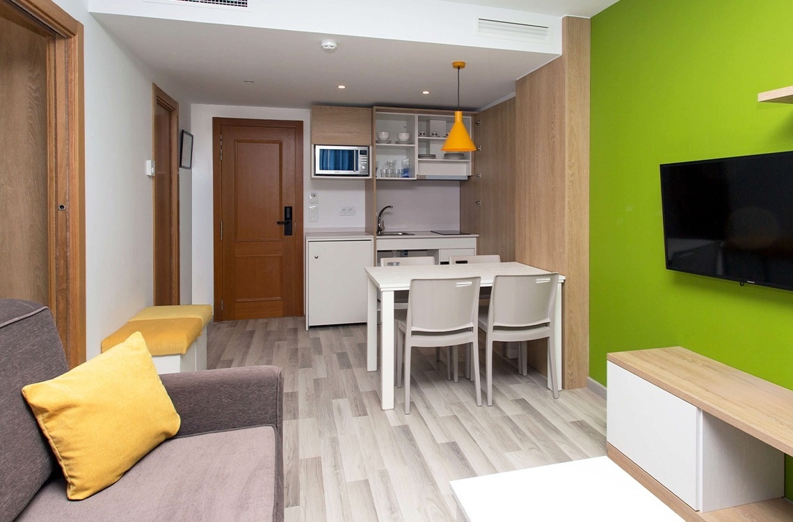 una habitación con una mesa y sillas y una televisión