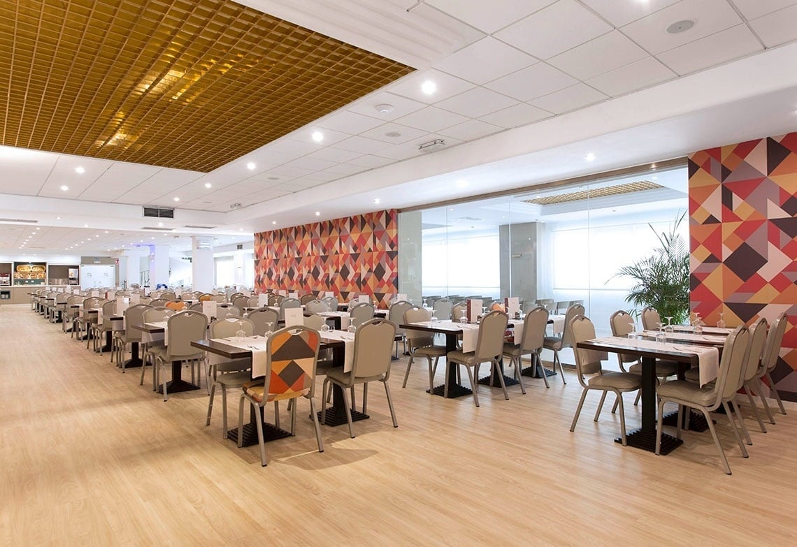 una larga fila de mesas y sillas en un restaurante