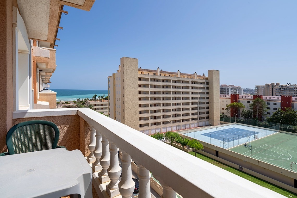 a view of a tennis court from a balcony overlooking the ocean