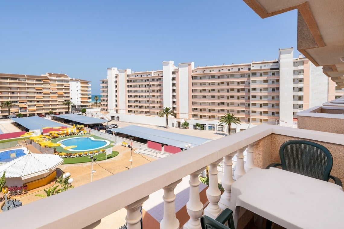 a balcony with a view of a pool and buildings