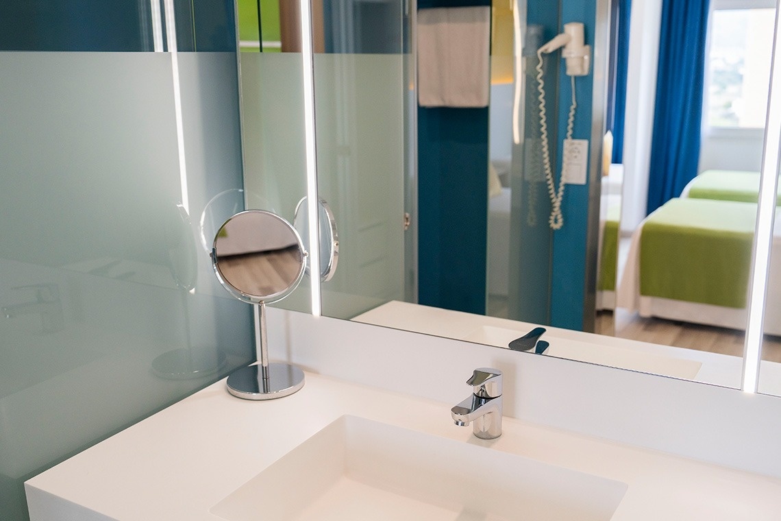 a bathroom with a sink a mirror and a hair dryer