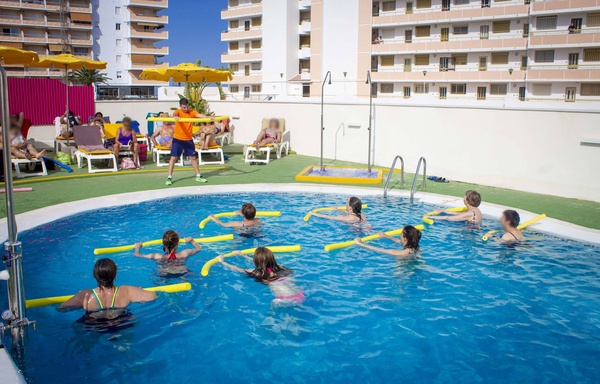 un grupo de niños están en un círculo con una niña que lleva una camiseta naranja