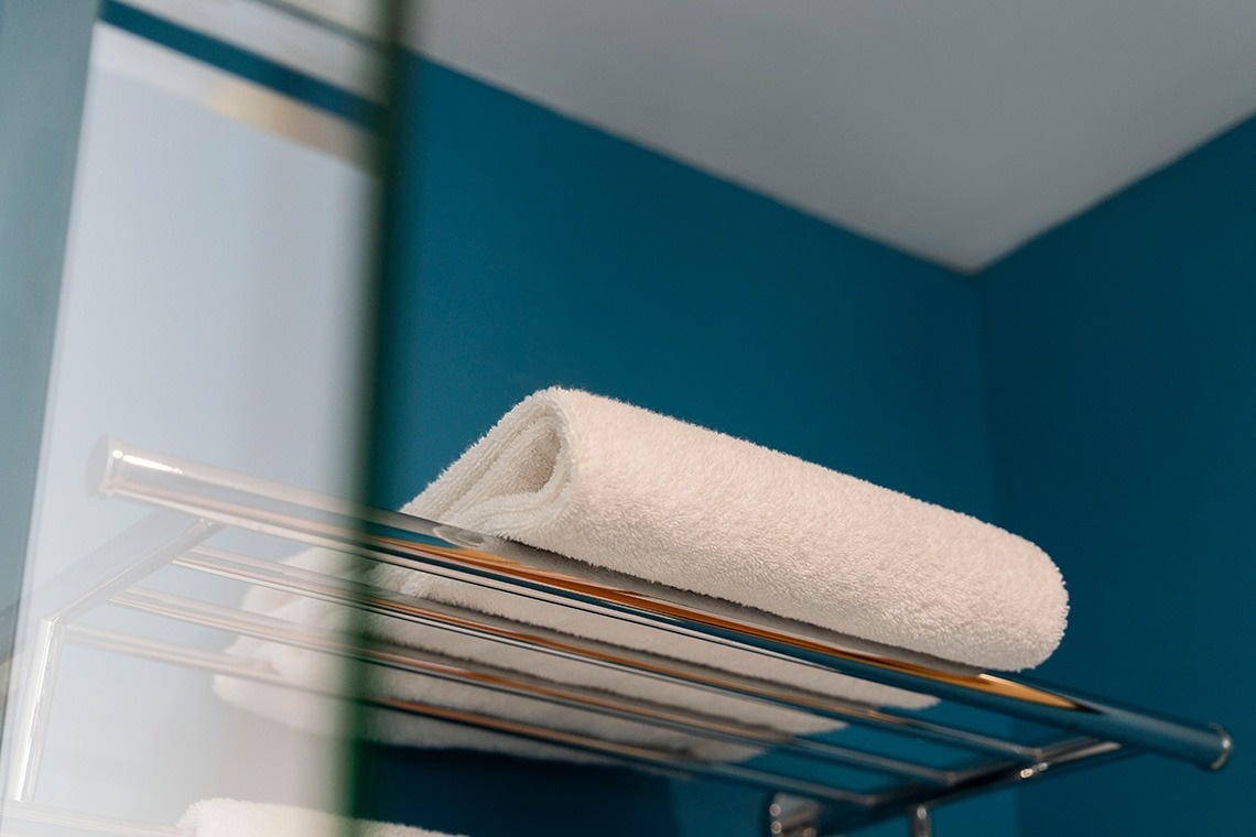 a white towel is on a towel rack in front of a mirror