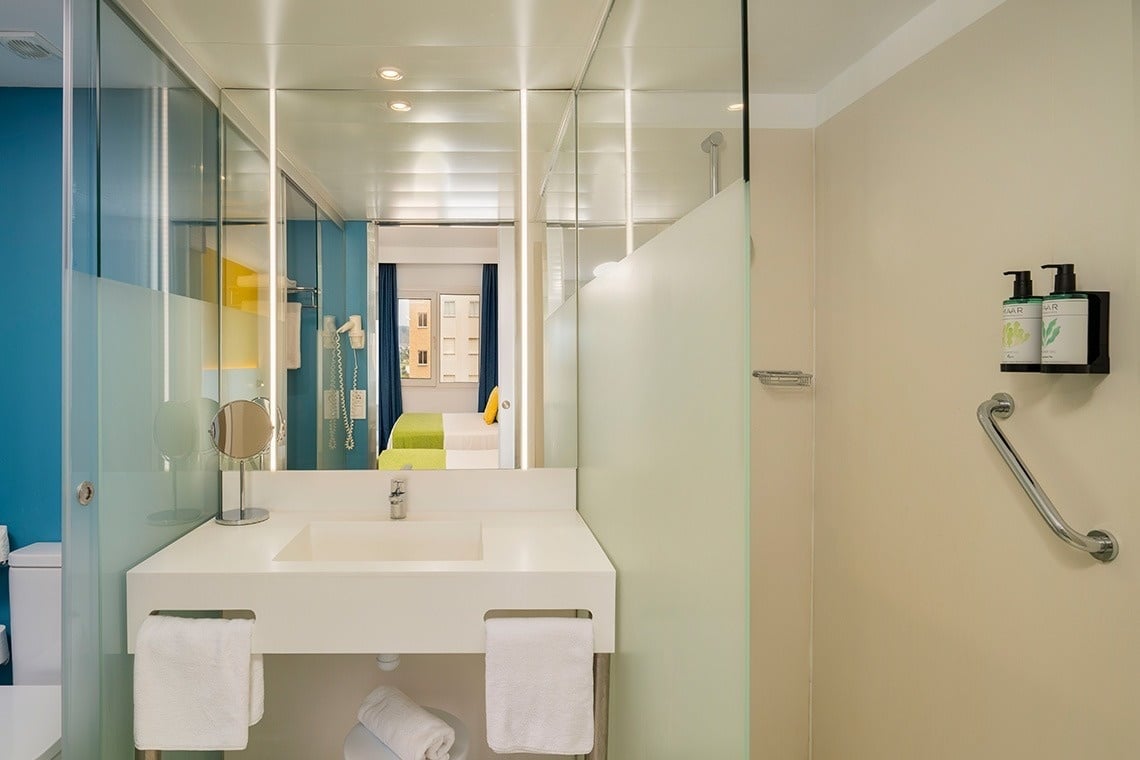 a bathroom with a sink and two bottles of soap on the wall