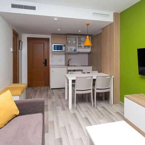 una habitación con una mesa y sillas y una televisión