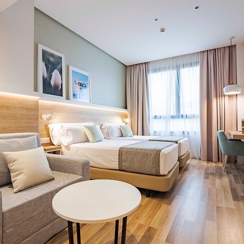 una habitación de hotel con dos camas y una mesa