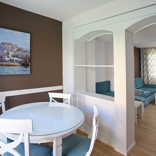 una habitación con una mesa y sillas y una pintura en la pared