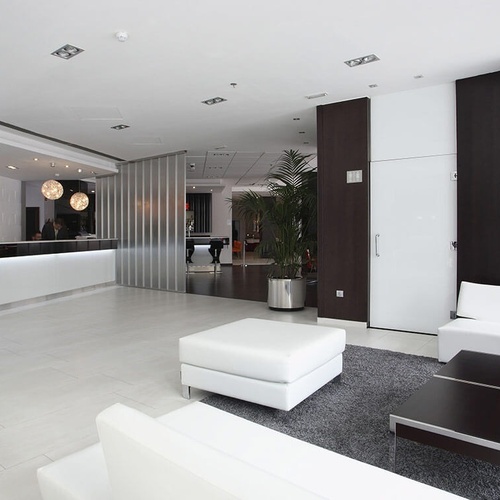 una sala de estar con muebles blancos y un mostrador de recepción