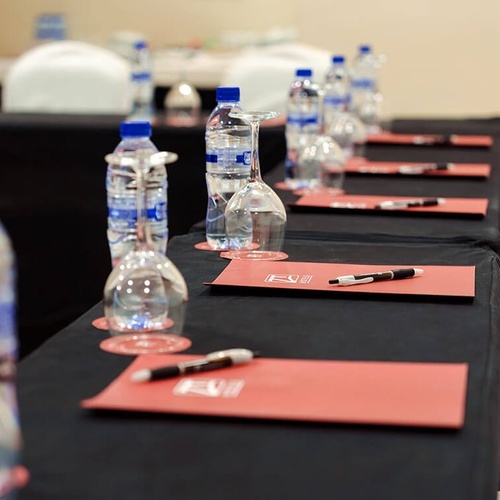 una fila de mesas con botellas de agua y copas