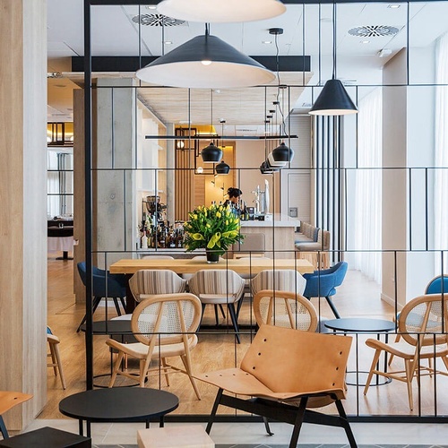 una sala de estar con sillas y mesas y un bar en el fondo