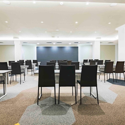 una sala de conferencias llena de mesas y sillas