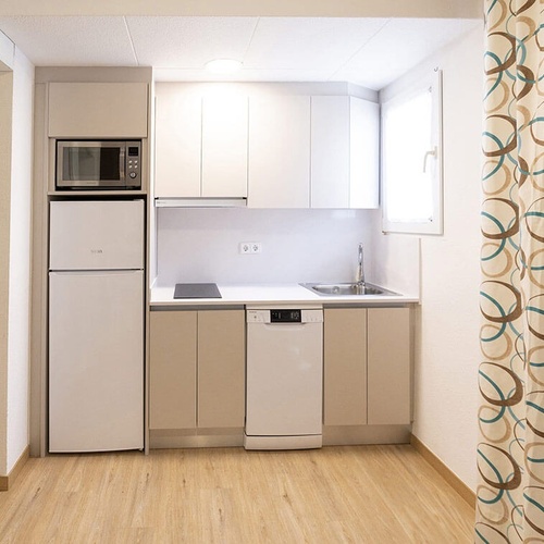 una pequeña cocina con electrodomésticos y una cortina de ducha