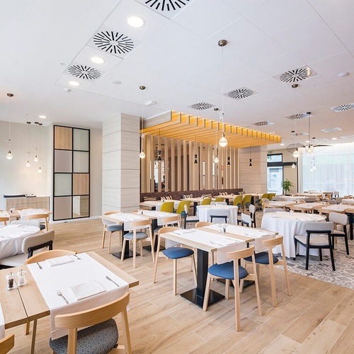 una gran sala de comedor con muchas mesas y sillas