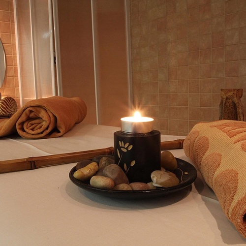 una mesa con toallas enrolladas y una vela encima