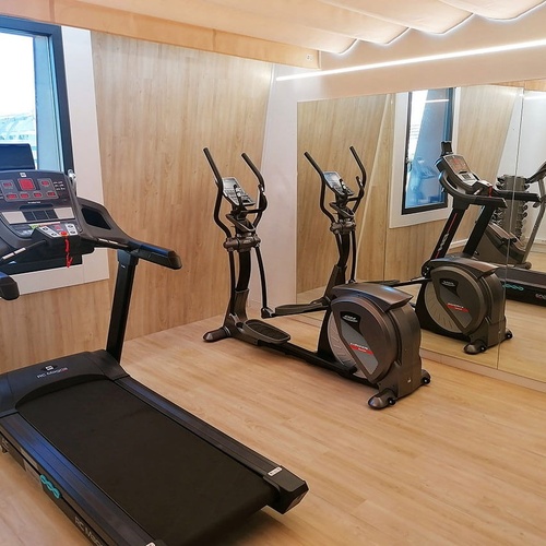 una cinta de correr y una bicicleta están frente a un espejo