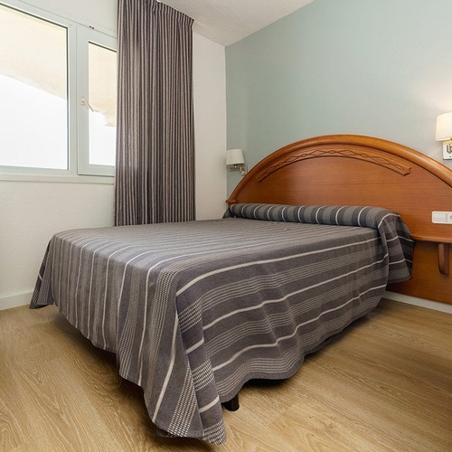 una habitación de hotel con una cama y una ventana