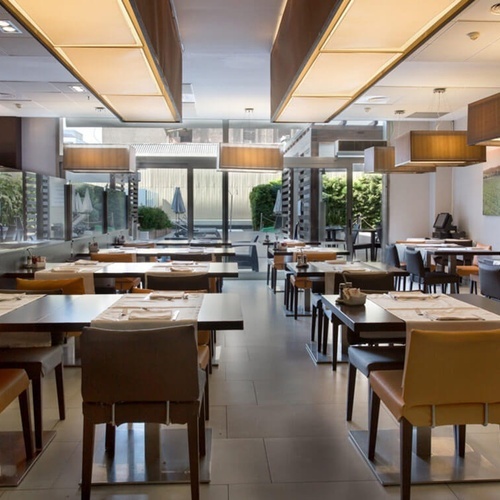 una larga fila de mesas y sillas en un restaurante