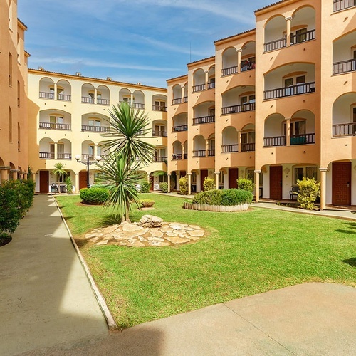 un edificio de apartamentos con balcones y césped